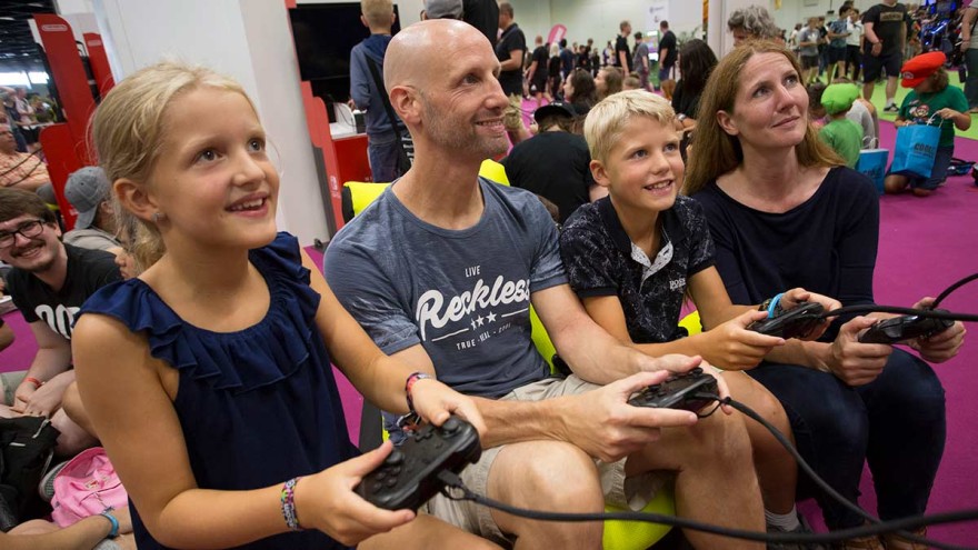 Family in front of a slot machine in the family & friends area at gamescom 2020 Family in front of a slot machine in the family & friends area at gamescom 2020