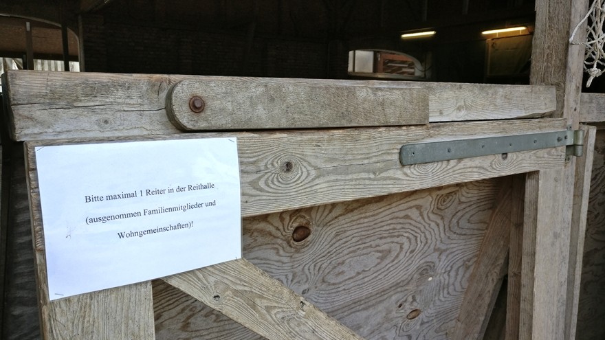 Stalltür mit Coronahinweis